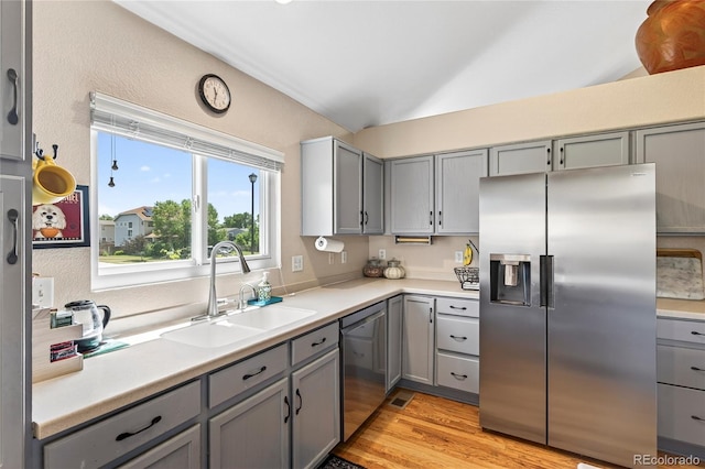 4737 E 127th Ave, Thornton, CO 80241 - kitchen featuring appliances with stainless steel finishes, gray cabinets, light wood-style floors, lofted ceiling, and light countertops