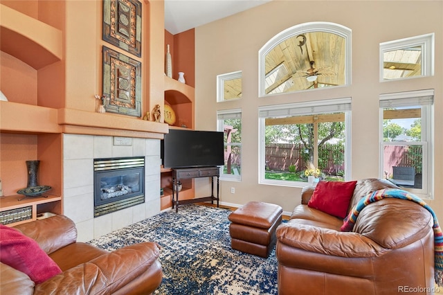 4737 E 127th Ave, Thornton, CO 80241 - living area with a ceiling fan, a high ceiling, and a tiled fireplace