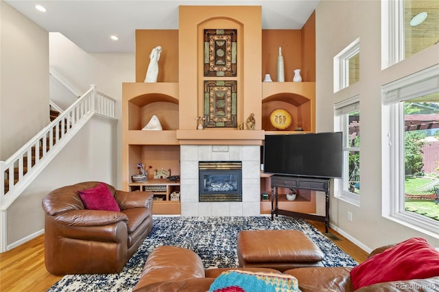 4737 E 127th Ave, Thornton, CO 80241 - living room with wood finished floors, a tiled fireplace, built in features, stairs, and a high ceiling