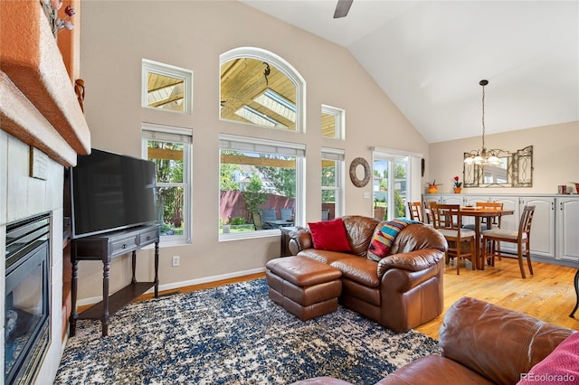 4737 E 127th Ave, Thornton, CO 80241 - living room with a fireplace, light wood finished floors, high vaulted ceiling, and a chandelier