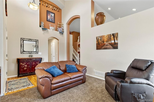 4737 E 127th Ave, Thornton, CO 80241 - carpeted living area featuring arched walkways, stairway, a towering ceiling, and recessed lighting