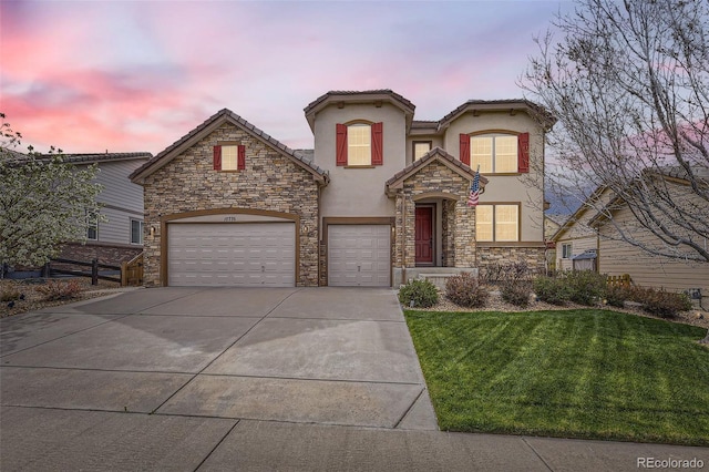 view of front of property with a tile roof, a yard, stucco siding, concrete driveway, and a garage