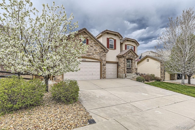 view of front of house with a garage, stone siding, concrete driveway, a tiled roof, and stucco siding