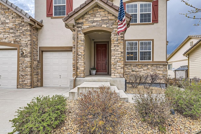 doorway to property with stone siding, concrete driveway, and stucco siding