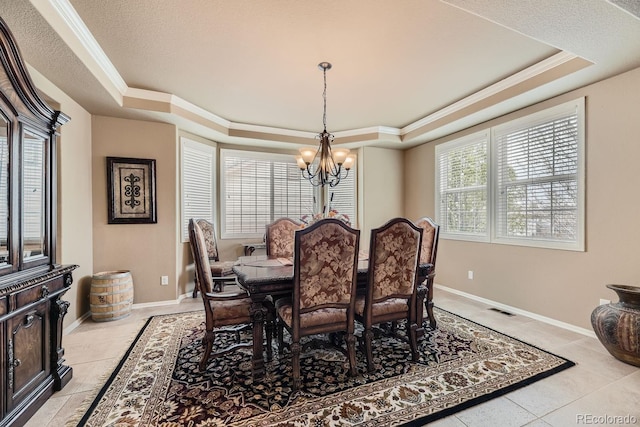 dining room with a chandelier, a tray ceiling, visible vents, and ornamental molding