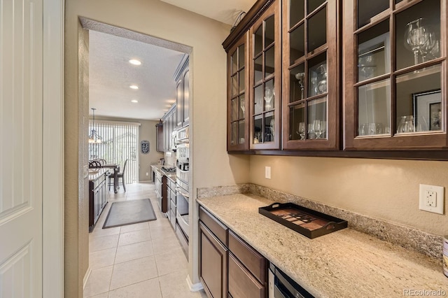 kitchen with light stone counters, recessed lighting, glass insert cabinets, light tile patterned flooring, and dark brown cabinets