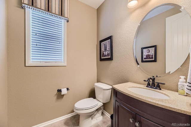 half bath with baseboards, a textured wall, toilet, tile patterned flooring, and vanity