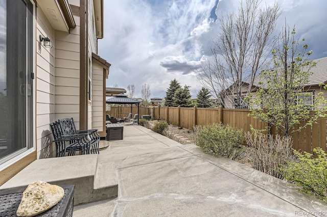 view of patio featuring a fenced backyard and a gazebo