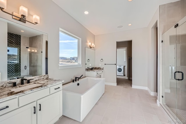 bathroom with vanity, washer / clothes dryer, shower with separate bathtub, and tile patterned floors