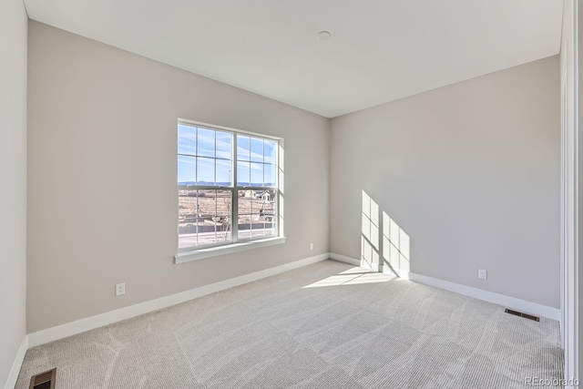 unfurnished room featuring light carpet