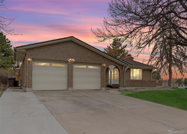 2696 S Yukon Ct, Lakewood, CO 80227 - ranch-style house featuring concrete driveway, brick siding, a garage, and a lawn
