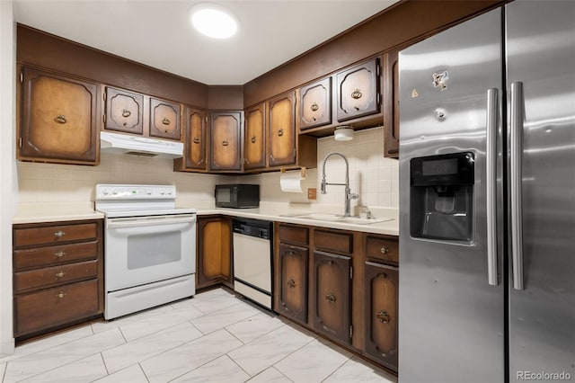 2696 S Yukon Ct, Lakewood, CO 80227 - kitchen with white appliances, under cabinet range hood, light countertops, and decorative backsplash
