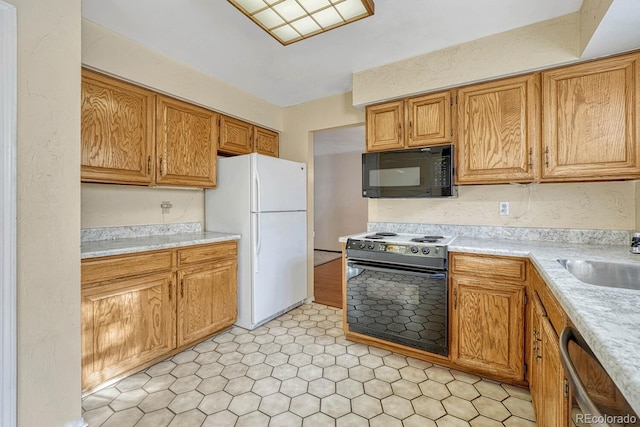 kitchen with dishwasher, white fridge, sink, and electric range