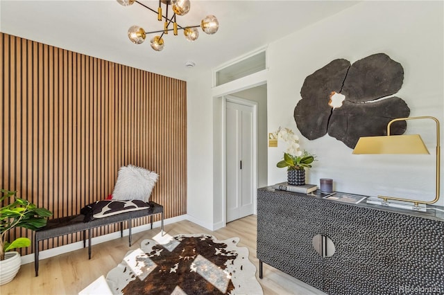 living area featuring a chandelier, wood finished floors, and baseboards