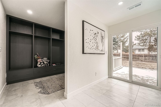 entryway with baseboards, recessed lighting, and a textured wall