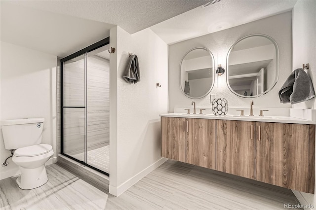 full bath featuring baseboards, a shower stall, toilet, and double vanity