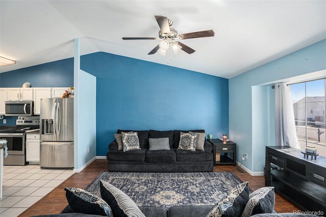 living area featuring lofted ceiling, a ceiling fan, and baseboards