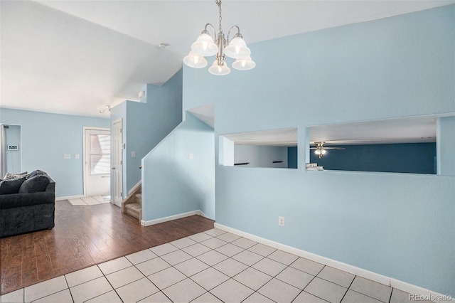 interior space with stairs, wood finished floors, a ceiling fan, and baseboards