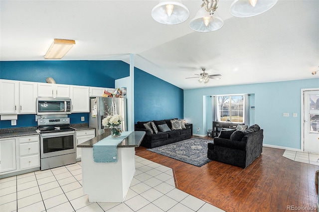 kitchen featuring appliances with stainless steel finishes, dark countertops, open floor plan, and vaulted ceiling