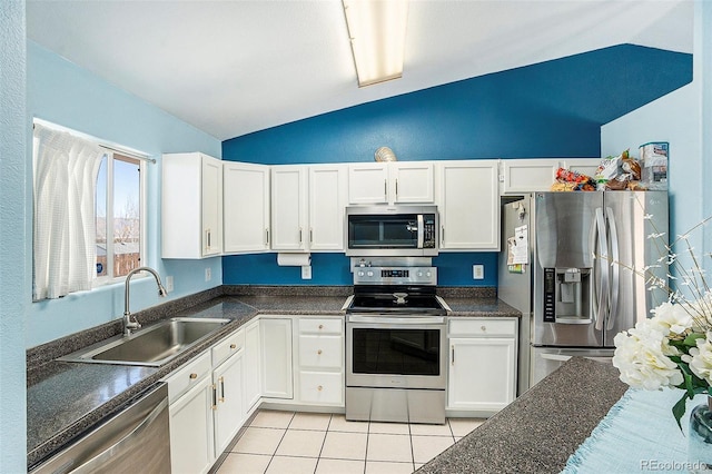 kitchen with light tile patterned floors, appliances with stainless steel finishes, a sink, and white cabinets