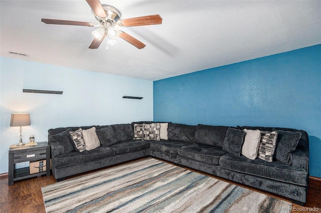 living room with ceiling fan, wood finished floors, and visible vents