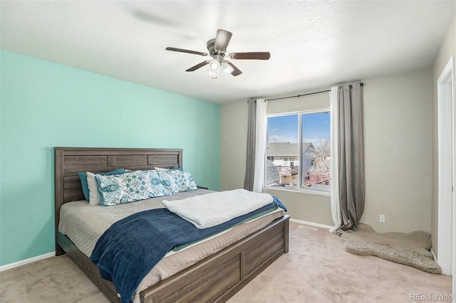 bedroom featuring ceiling fan, a textured ceiling, carpet flooring, visible vents, and baseboards