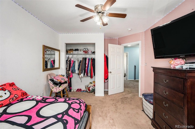 bedroom with a ceiling fan, a closet, and light carpet