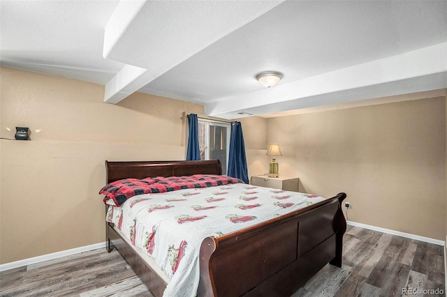 bedroom with wood finished floors and baseboards