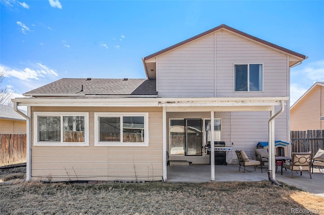 rear view of property with crawl space, roof with shingles, a patio area, and fence