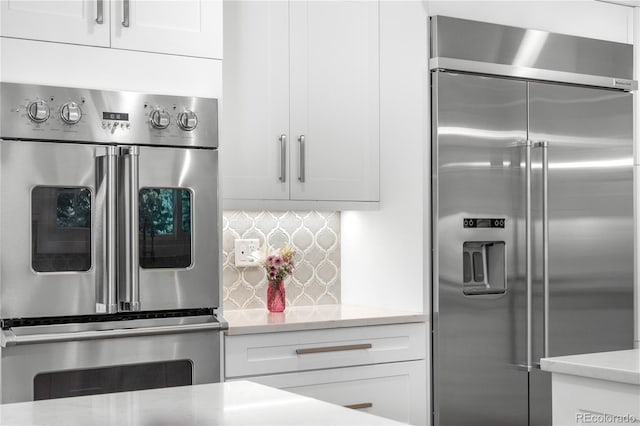6795 E Kettle Ave, Centennial, CO 80112 - kitchen with stainless steel appliances, white cabinetry, tasteful backsplash, and light stone counters