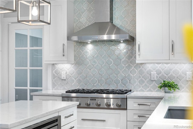6795 E Kettle Ave, Centennial, CO 80112 - kitchen featuring wall chimney exhaust hood, stainless steel gas cooktop, white cabinets, tasteful backsplash, and light stone counters