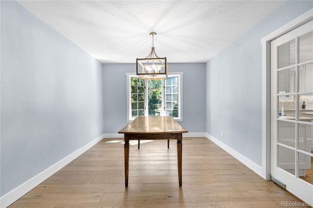 6795 E Kettle Ave, Centennial, CO 80112 - unfurnished dining area featuring a chandelier, light wood finished floors, and a textured ceiling