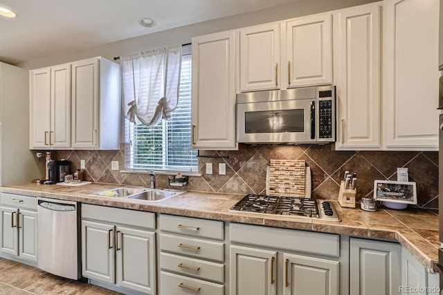 kitchen with sink, white cabinetry, appliances with stainless steel finishes, and tasteful backsplash