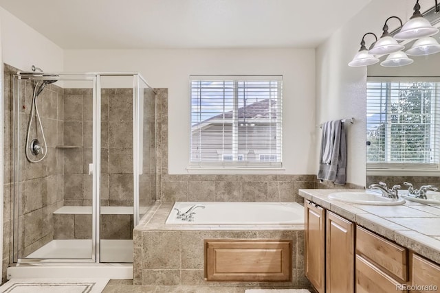 bathroom with plus walk in shower, a wealth of natural light, and vanity