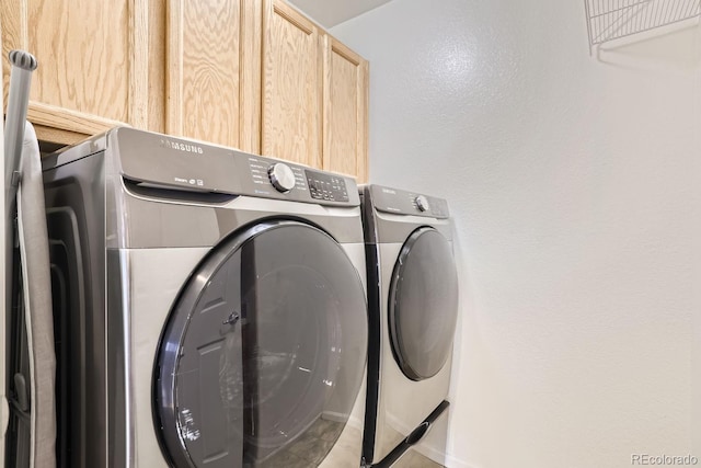 laundry area with cabinets and washer and clothes dryer