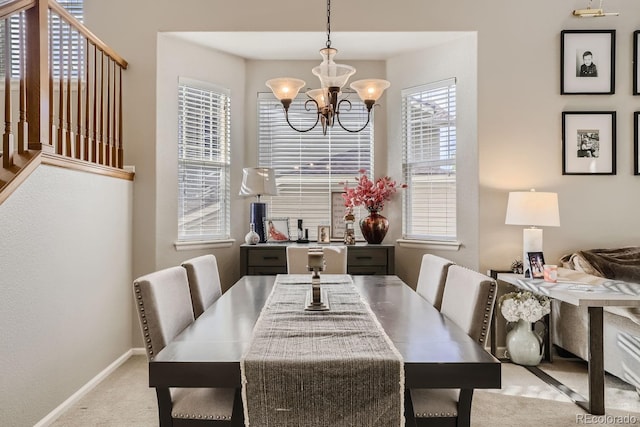 dining room with light colored carpet and an inviting chandelier