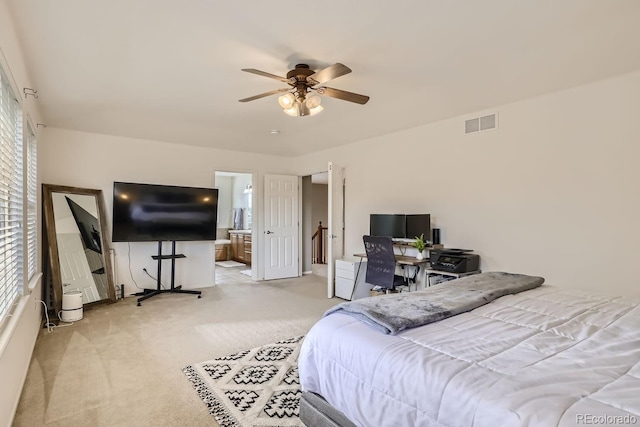 carpeted bedroom with ceiling fan, multiple windows, and connected bathroom