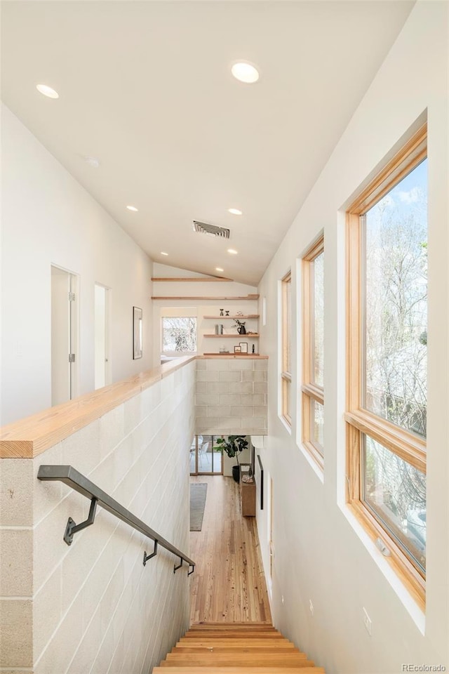 staircase featuring recessed lighting, vaulted ceiling, visible vents, and wood finished floors