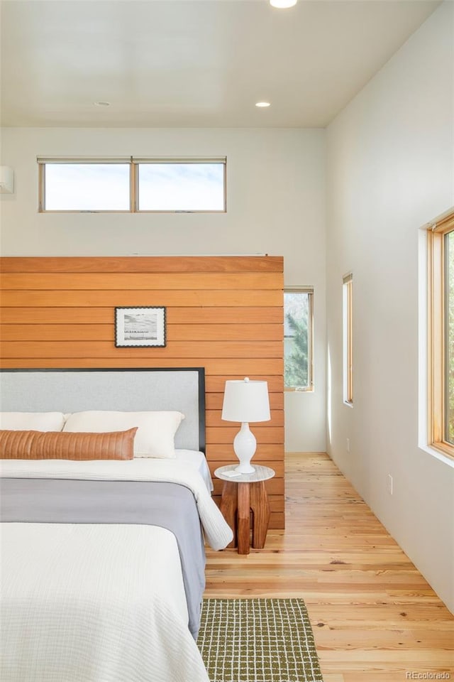 bedroom with wood finished floors, recessed lighting, and multiple windows
