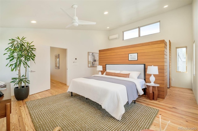 bedroom featuring recessed lighting, a towering ceiling, and light wood-type flooring