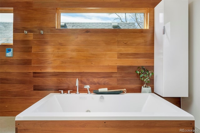 bathroom featuring wooden walls and a bathtub