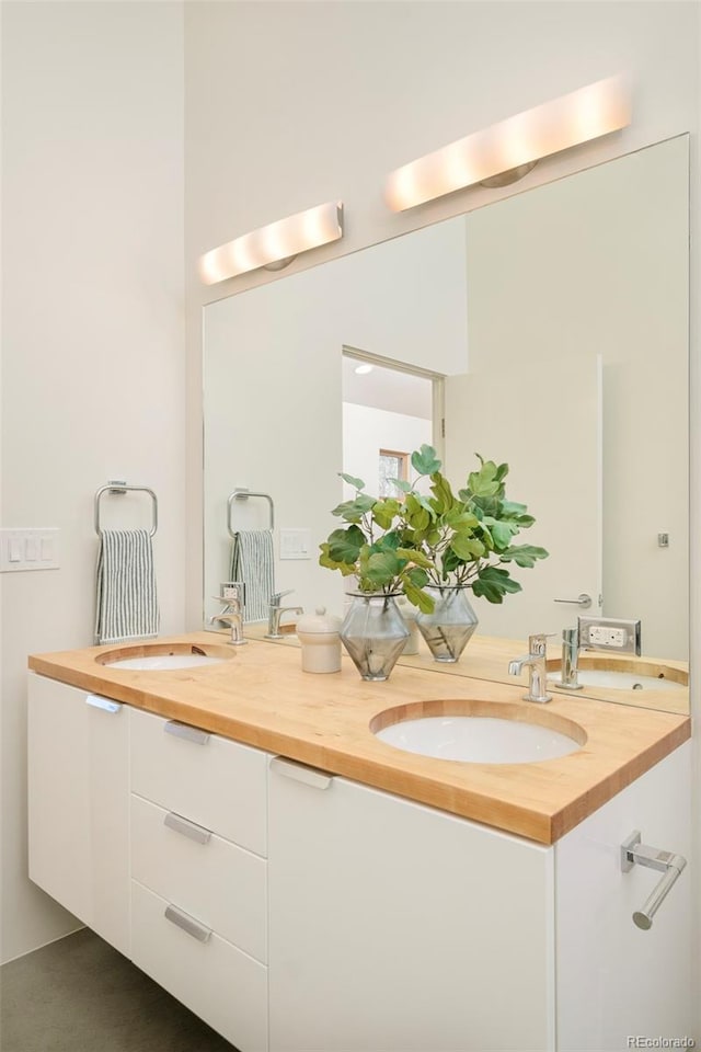 bathroom with a sink and double vanity
