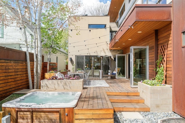 deck with fence and an outdoor hot tub