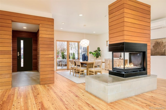 living area with wood finished floors, recessed lighting, and a multi sided fireplace