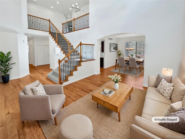 2180 Trailblazer Way, Castle Rock, CO 80109 - living room with arched walkways, a high ceiling, stairway, wood finished floors, and recessed lighting