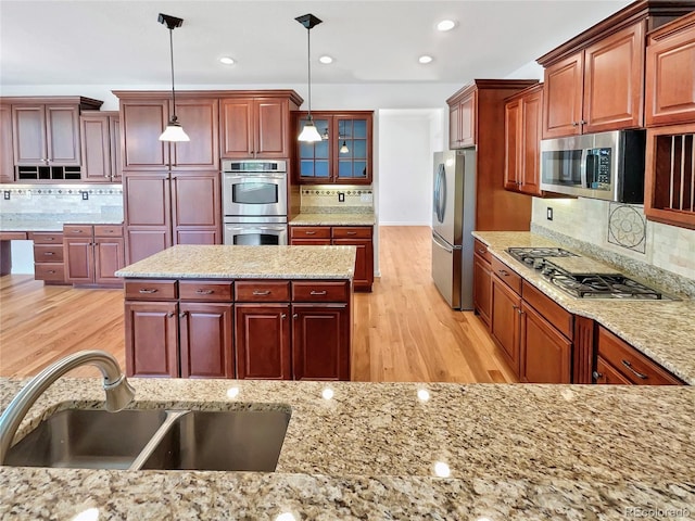 2180 Trailblazer Way, Castle Rock, CO 80109 - kitchen with stainless steel appliances, backsplash, light wood finished floors, a sink, and recessed lighting
