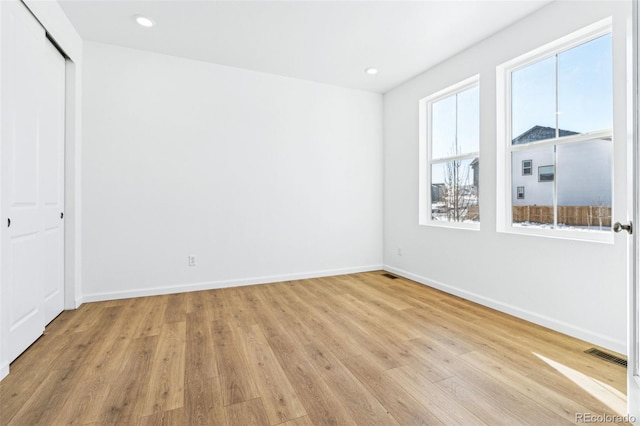 unfurnished bedroom featuring light hardwood / wood-style flooring and a closet