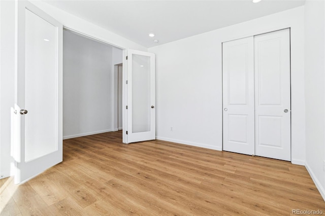 unfurnished bedroom featuring light hardwood / wood-style flooring and a closet