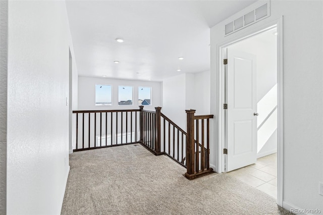 hallway featuring light colored carpet