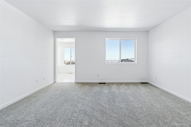 carpeted empty room featuring a textured ceiling